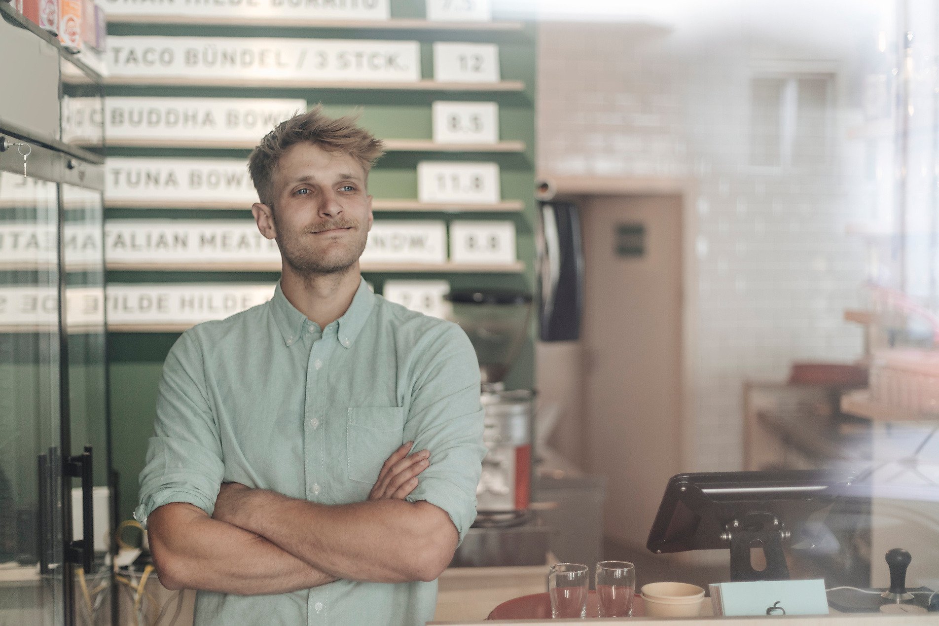 A contented man crosses his arms in a small restaurant