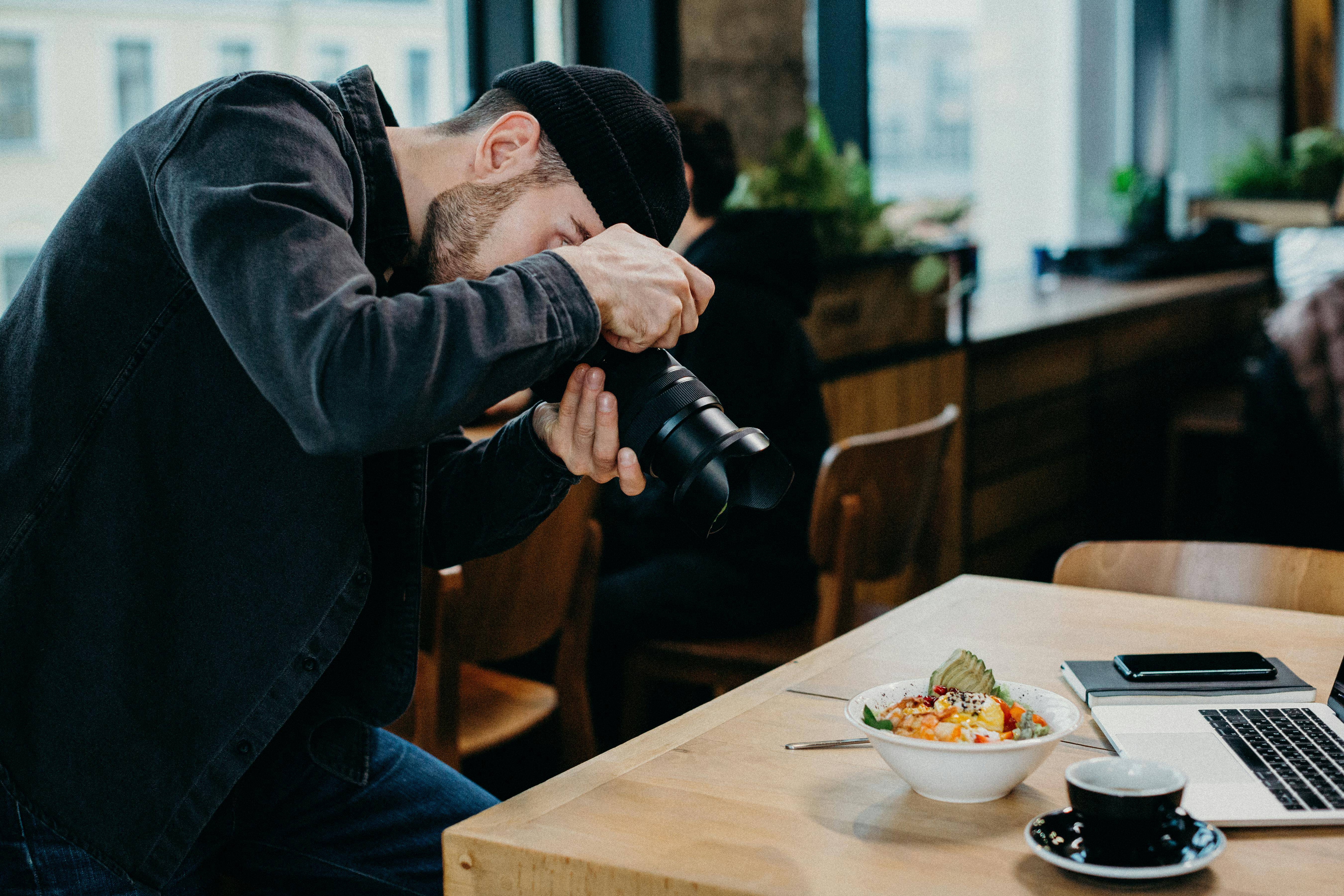 Ein Fotograf macht ein Foto von einem schön gedeckten Tisch in einem Restaurant.