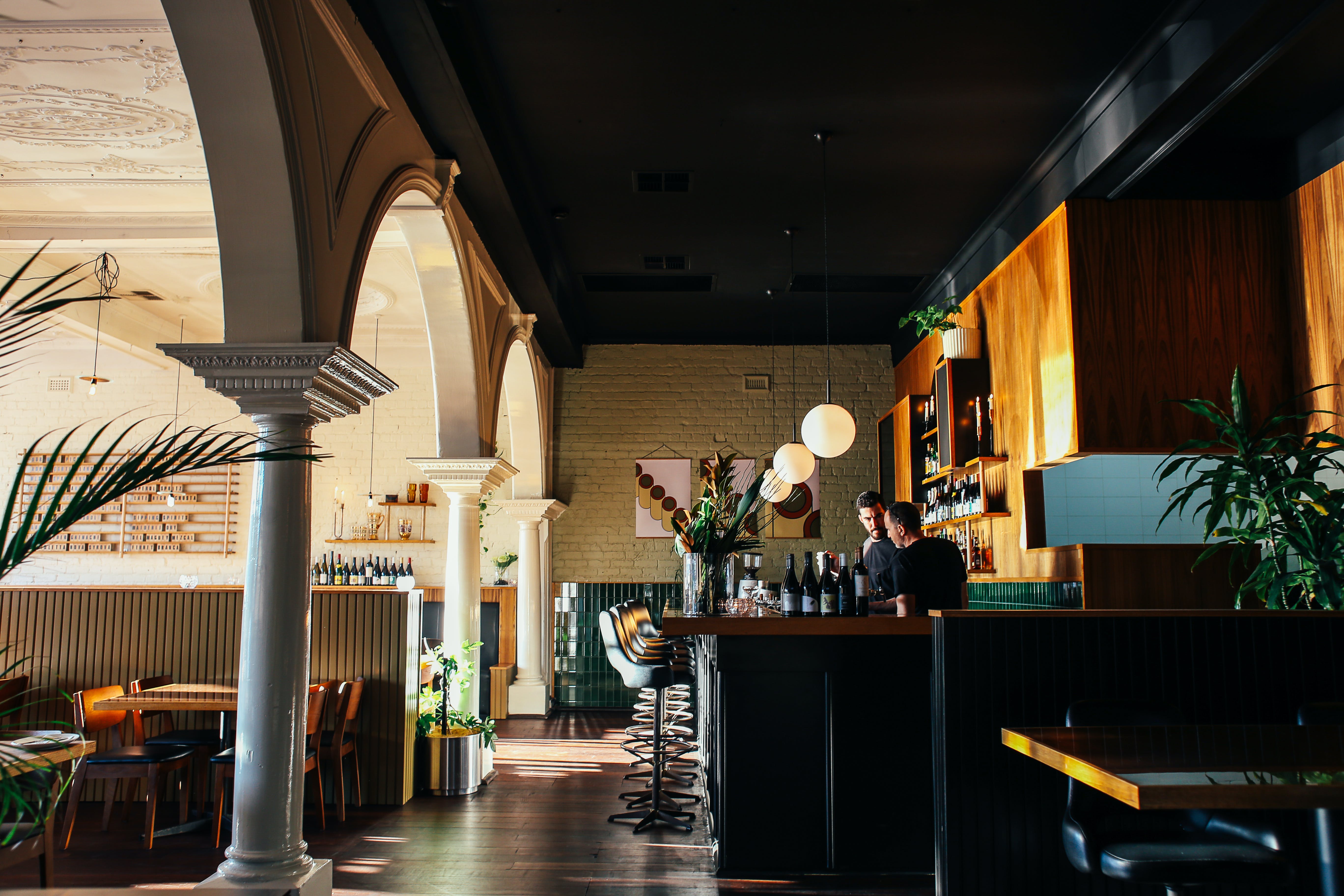 A fancy restaurant with two employees behind the bar and no customers.