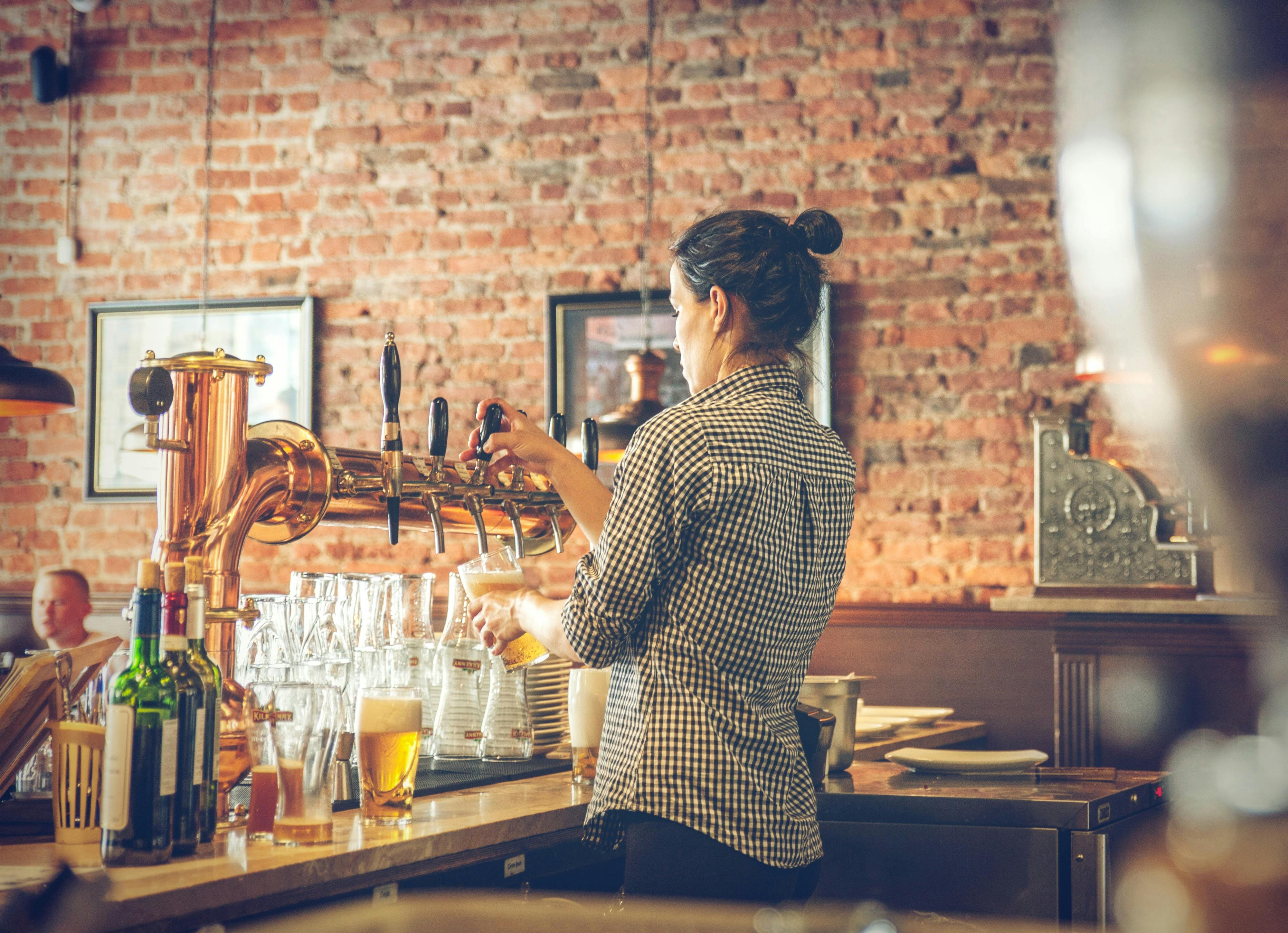 Employee taps beer in a cozy restaurant