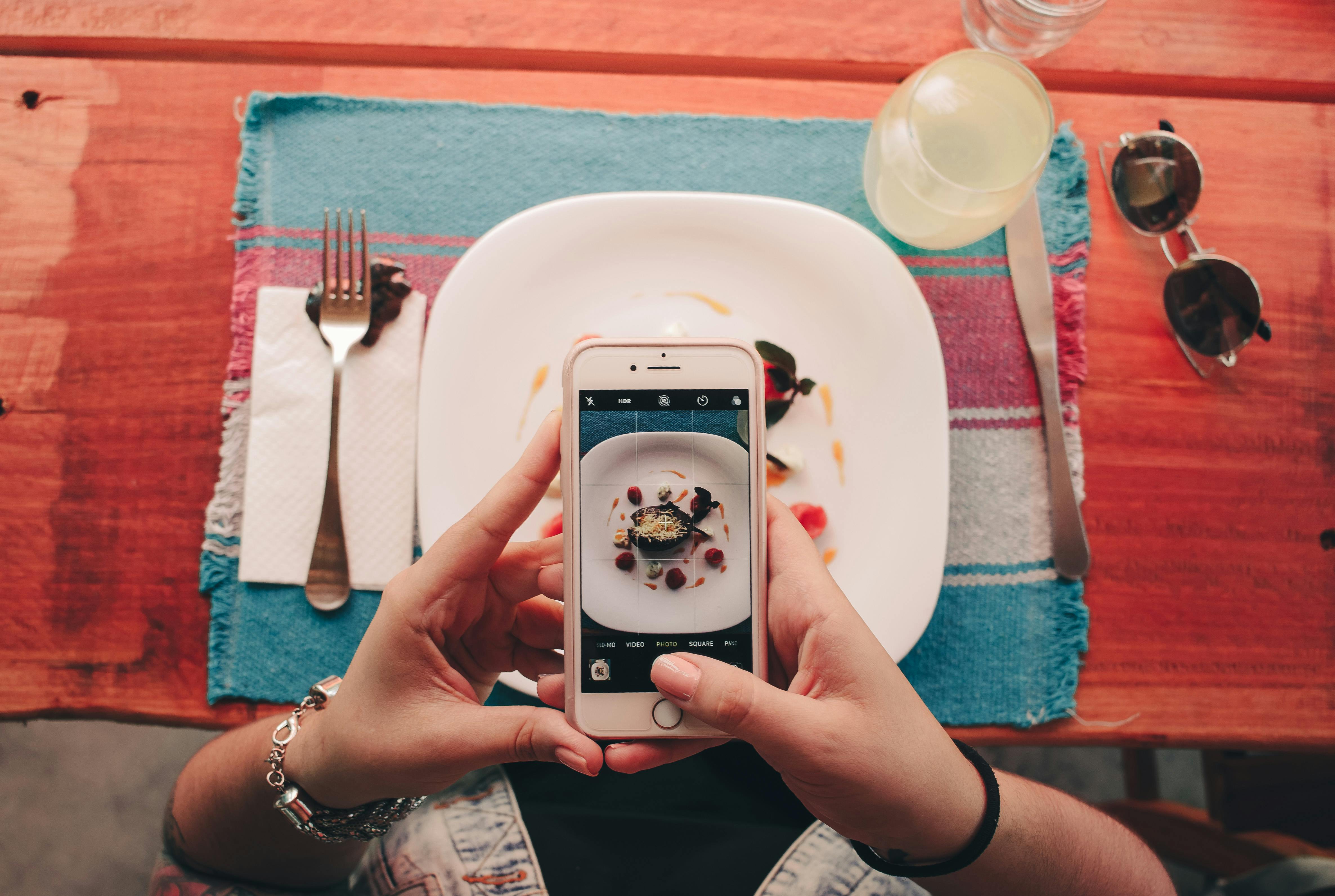 Gast fotografiert Gericht mit Smartphone