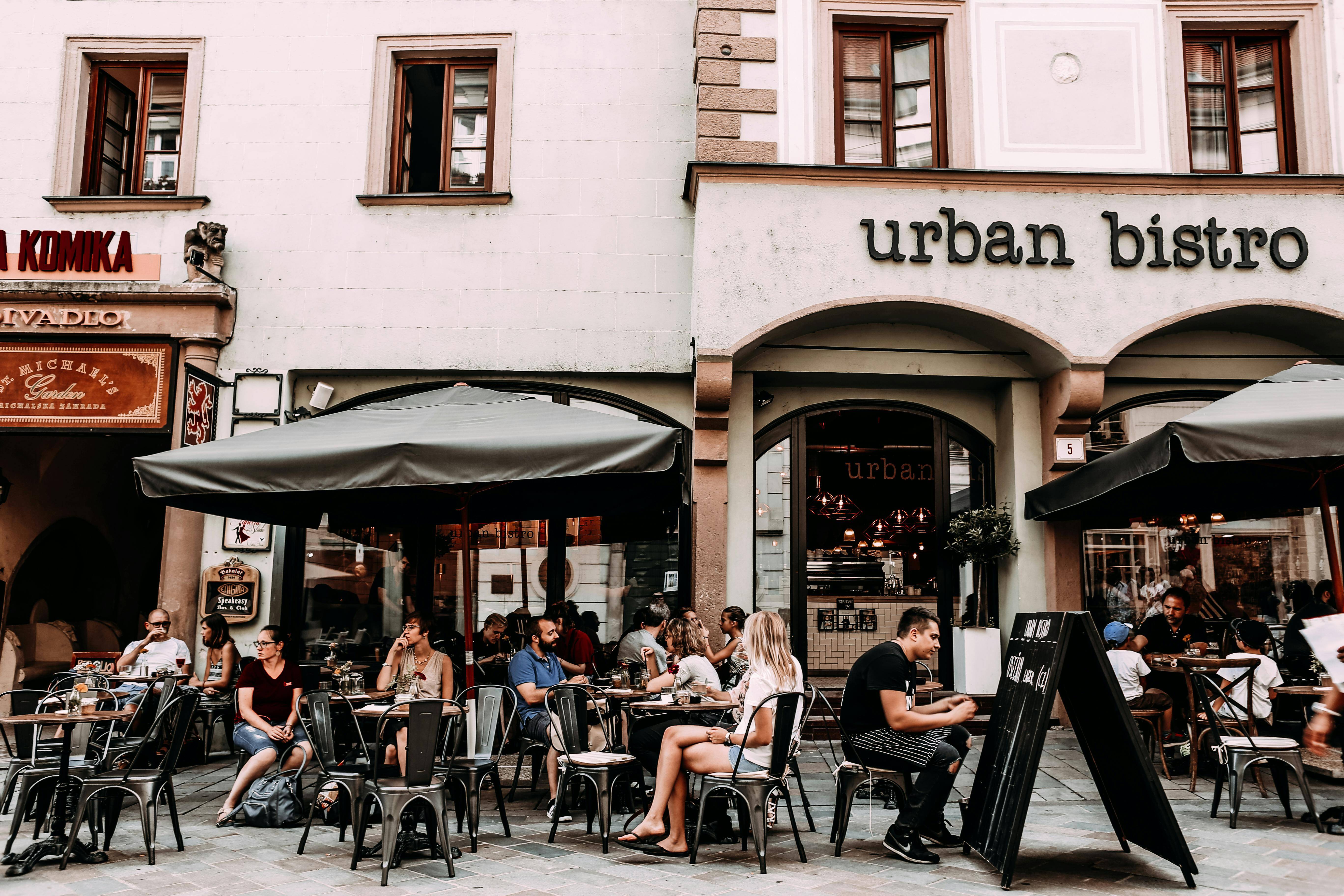 Der Außenbereich eines vollen Bistros mit vielen Gästen.