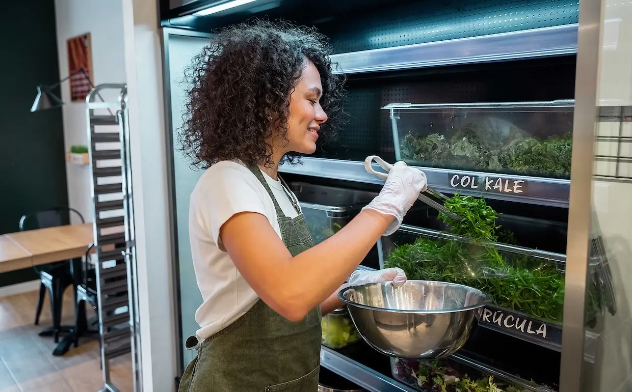 Köchin bereitet Salad zu